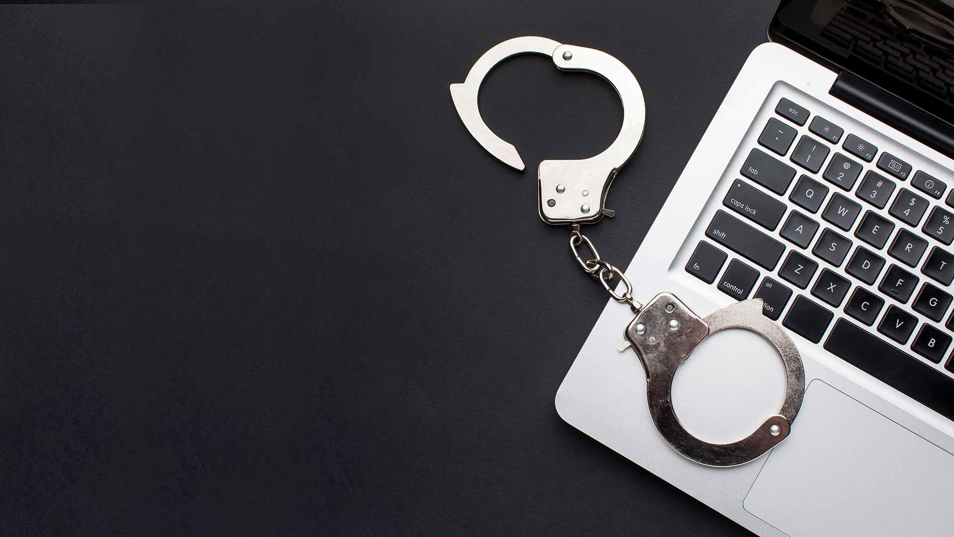 flat-lay-handcuffs-with-laptop-copy-space
